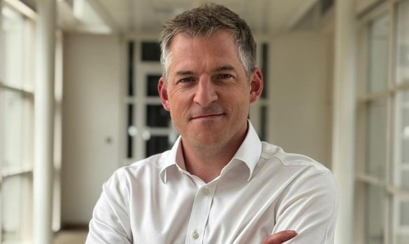 Headshot of a man wearing a white shirt.